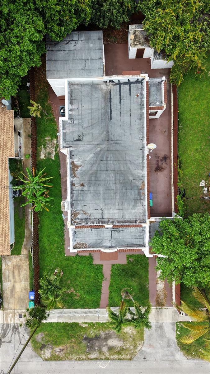 An aerial view shows a flat-roofed house with a backyard and surrounding landscaping — 1727 NW 50th St, Miami FL 33142, MIAMI, FL