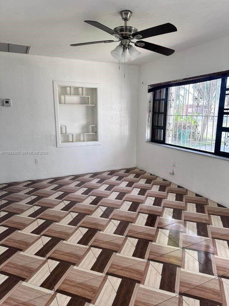An empty room features a patterned tile floor, a ceiling fan, and a built-in wall niche — 576 NW 147th St # 576, Miami FL 33168, MIAMI, FL