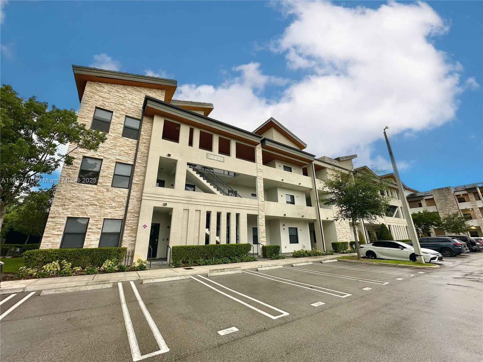 A three-story apartment building with stone veneer accents and a parking lot in front — 8031 NW 104th Ave # 21, Doral FL 33178, DORAL, FL