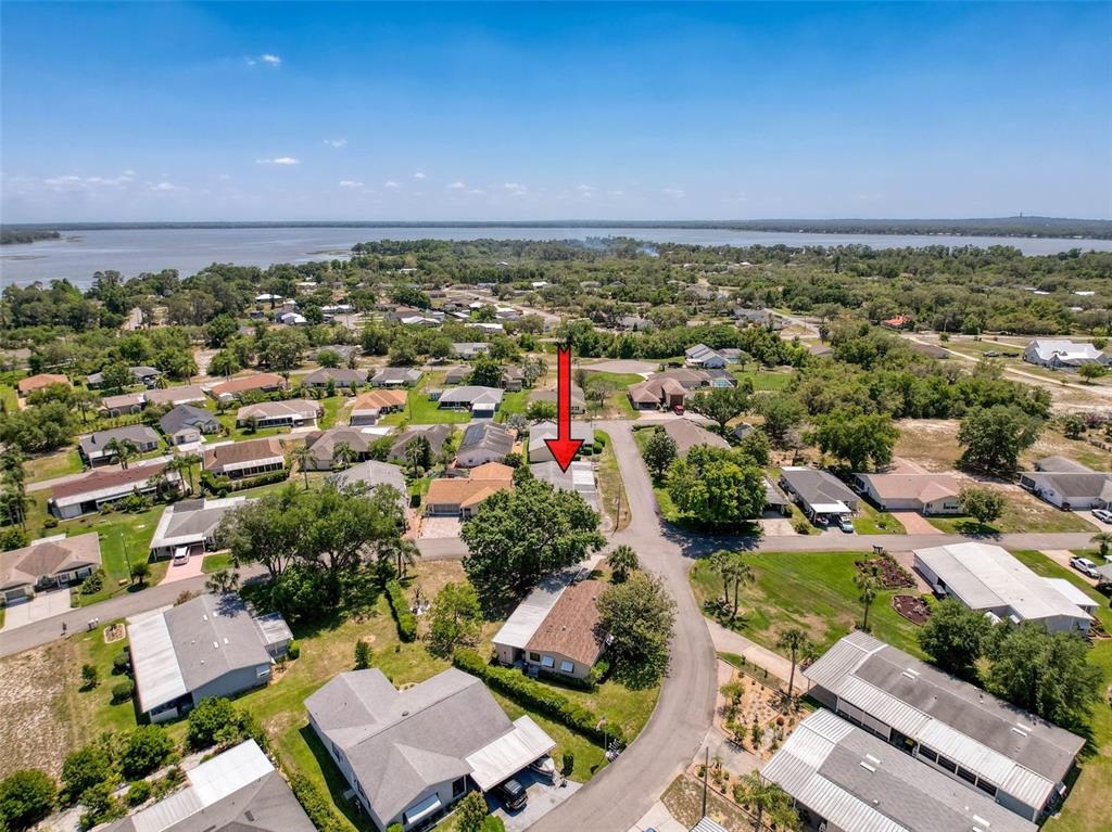 An aerial view shows a residential neighborhood with a red arrow pointing to a house — 4202 ORCHID BOULEVARD, LAKE WALES, FL