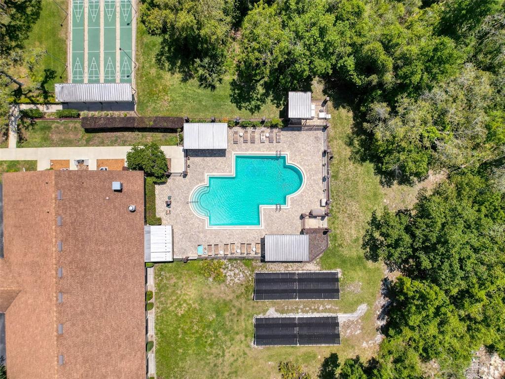 An aerial view shows a swimming pool, shuffleboard courts, and solar panels on a grassy lot — 4202 ORCHID BOULEVARD, LAKE WALES, FL