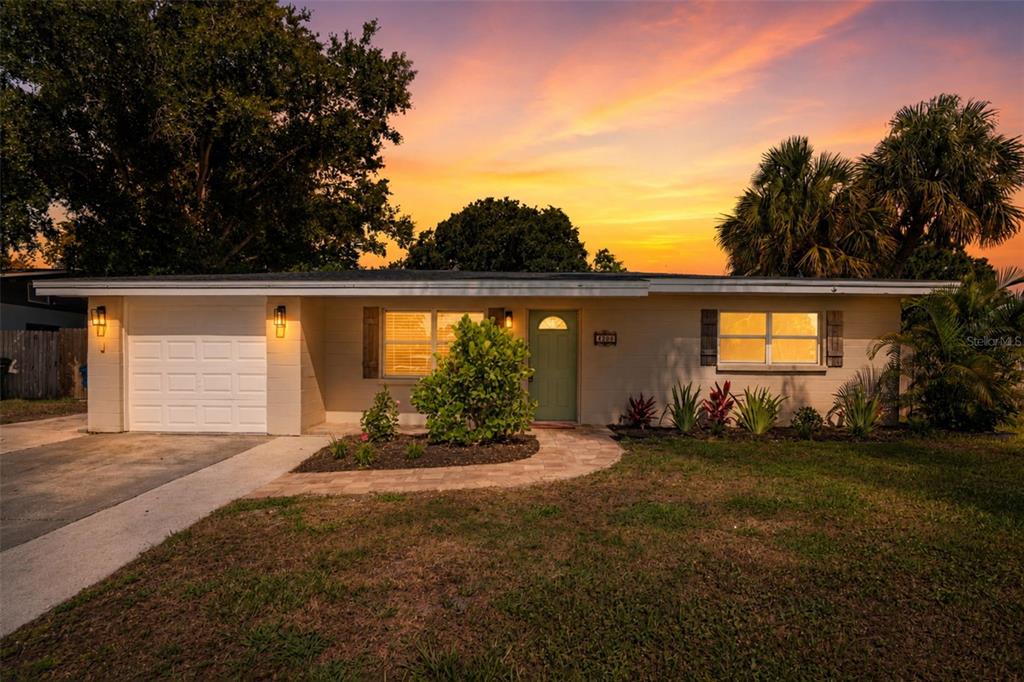 A single-story house with a white garage, light-colored siding, and a green front door — 4200 DES PLAINES DRIVE, SARASOTA, FL