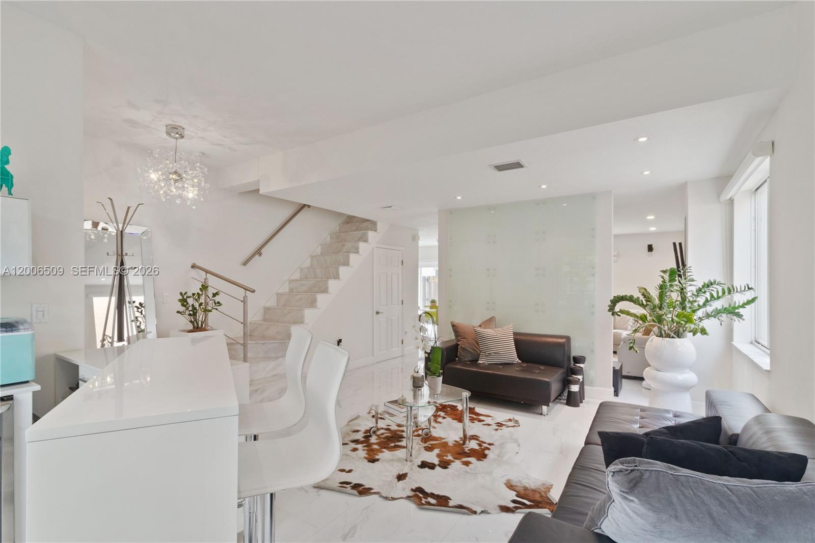 A modern living room features white marble floors, a staircase, and a glass partition wall — 10842 NW 53rd Ln, Doral FL 33178, DORAL, FL