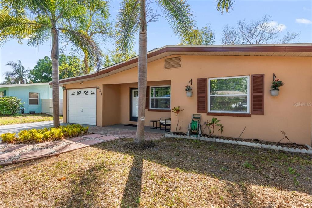 A single-story house with a peach exterior, a garage, and a front yard with palm trees — 611 11TH STREET NW, LARGO, FL