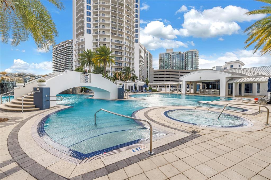 A swimming pool with a footbridge and a hot tub sits before a high-rise building — 449 S 12TH STREET UNIT 1205, TAMPA, FL