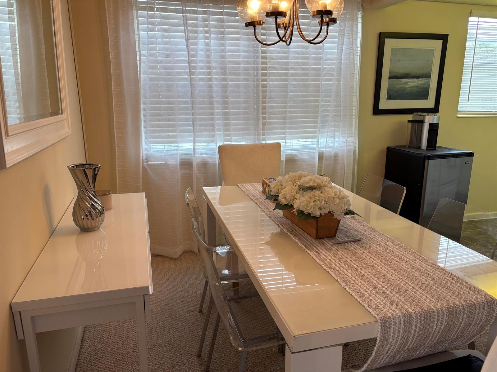 A dining room features a white table, clear chairs, a centerpiece, and a side console — 112 C Preston Way # C, Boca Raton FL 33434, BOCA RATON, FL