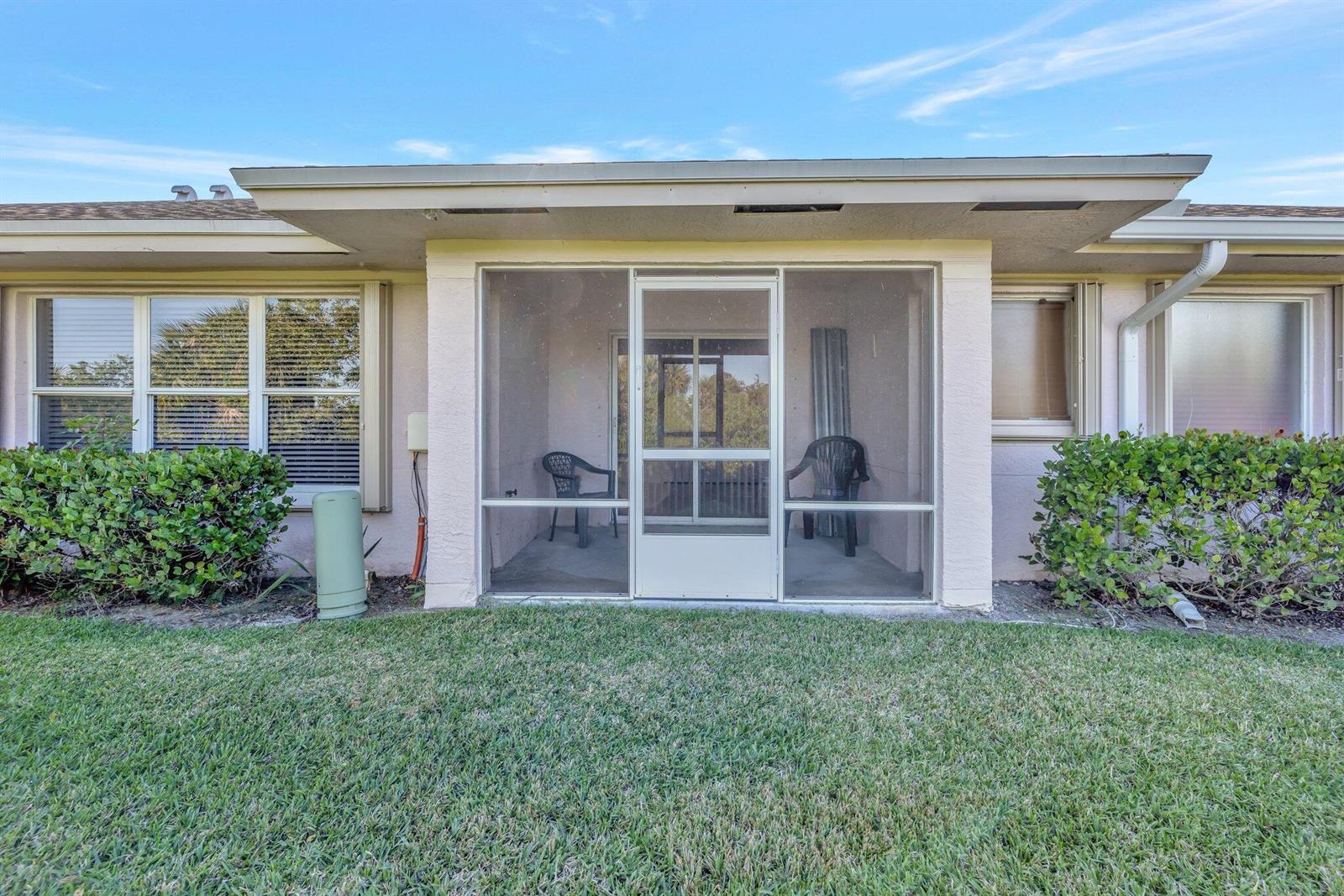 A screened-in patio sits between two windows on the exterior of a residential building — 1804 E Sanderling Lane # B, Fort Pierce FL 34982, FORT PIERCE, FL