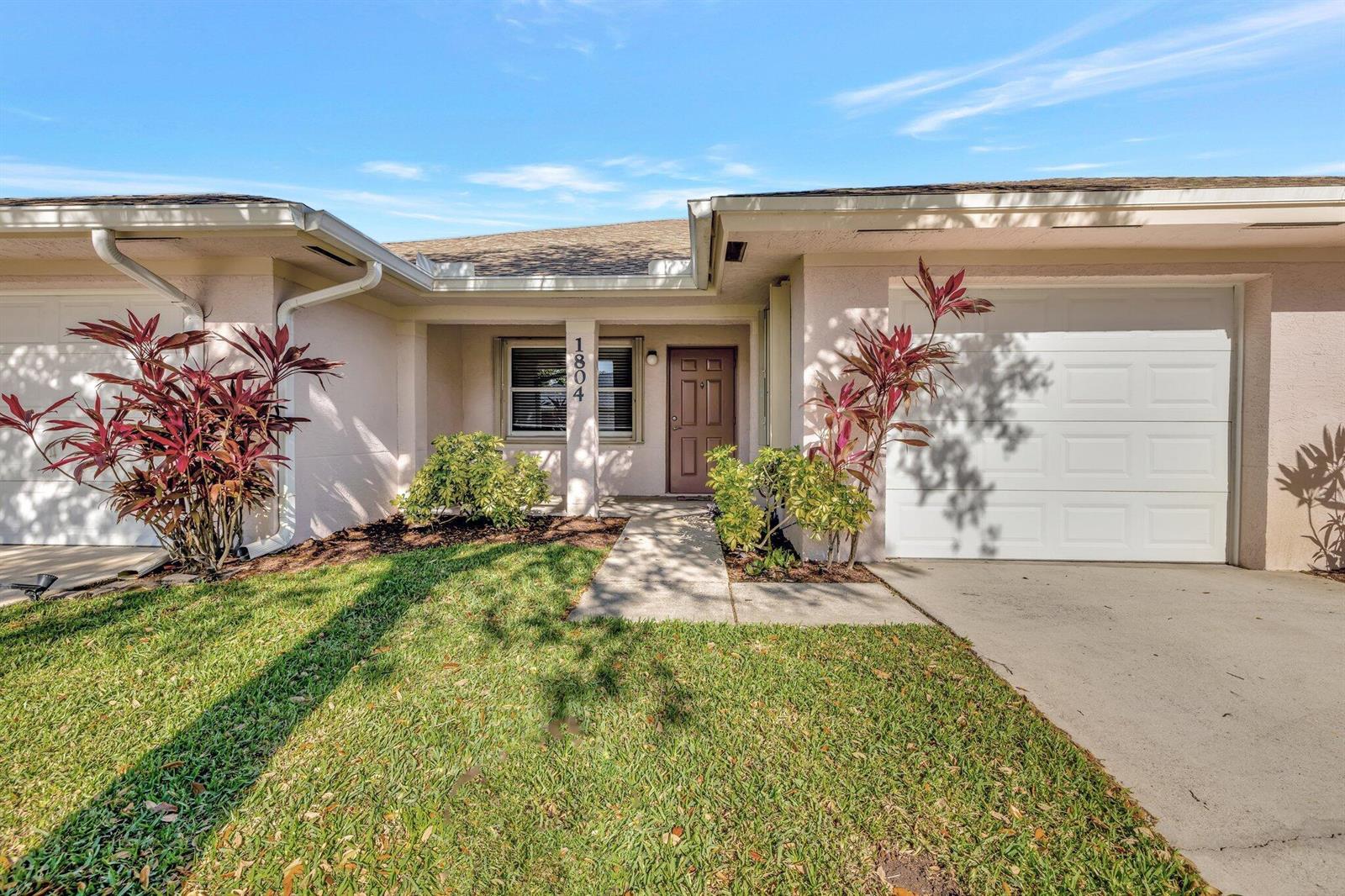 A single-story house exterior features a front entrance, a garage, and a small lawn — 1804 E Sanderling Lane # B, Fort Pierce FL 34982, FORT PIERCE, FL