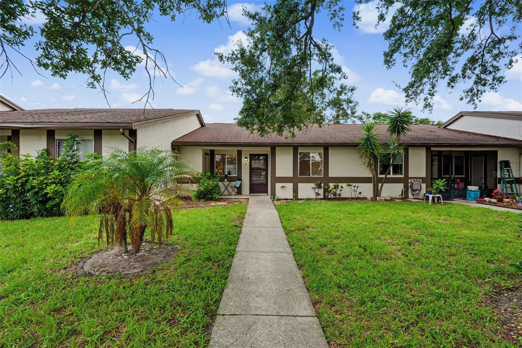 A single-story residential building with a concrete walkway leading to the front entrance — 2265 BANCROFT CIRCLE S UNIT C, PALM HARBOR, FL