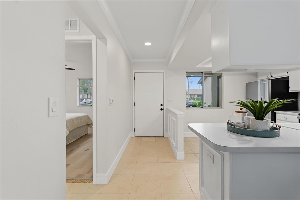 A view from a kitchen counter looking toward a white front door and bedroom entrance — 2265 BANCROFT CIRCLE S UNIT C, PALM HARBOR, FL