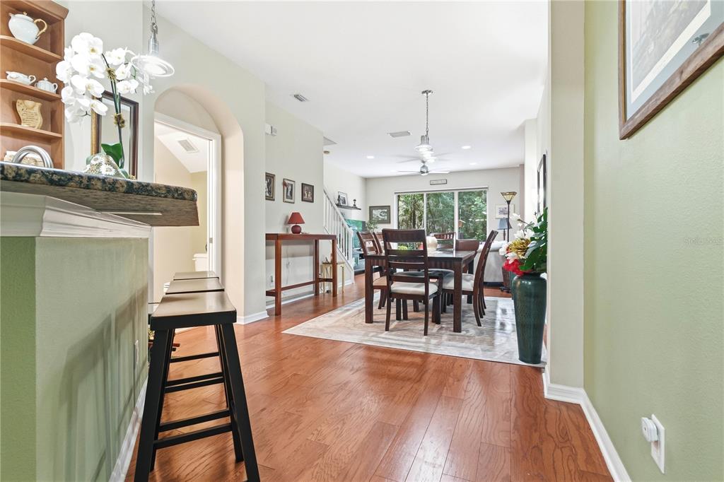 A dining area with a wooden table and chairs sits on a rug near stairs — 12658 SILVERDALE STREET, TAMPA, FL