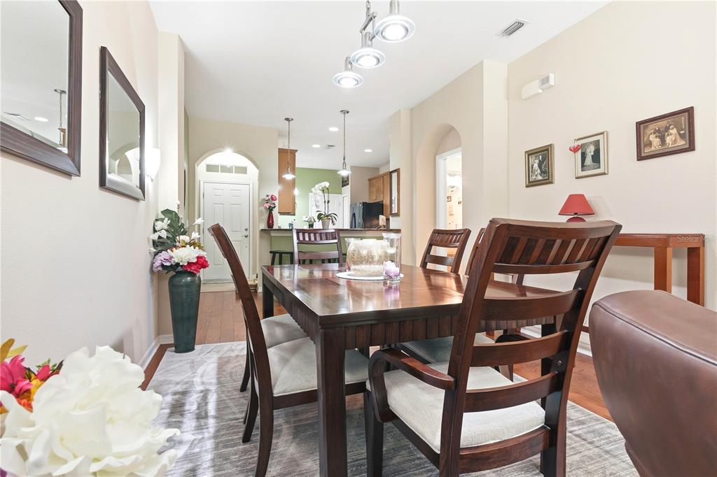 A dining room features a dark wood table, matching chairs, and a light-colored area rug — 12658 SILVERDALE STREET, TAMPA, FL