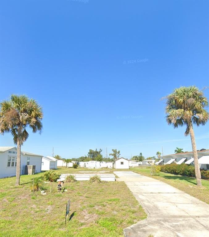 A vacant lot with a concrete driveway and two palm trees under a clear sky — 1510 SANDERLING DRIVE, ENGLEWOOD, FL