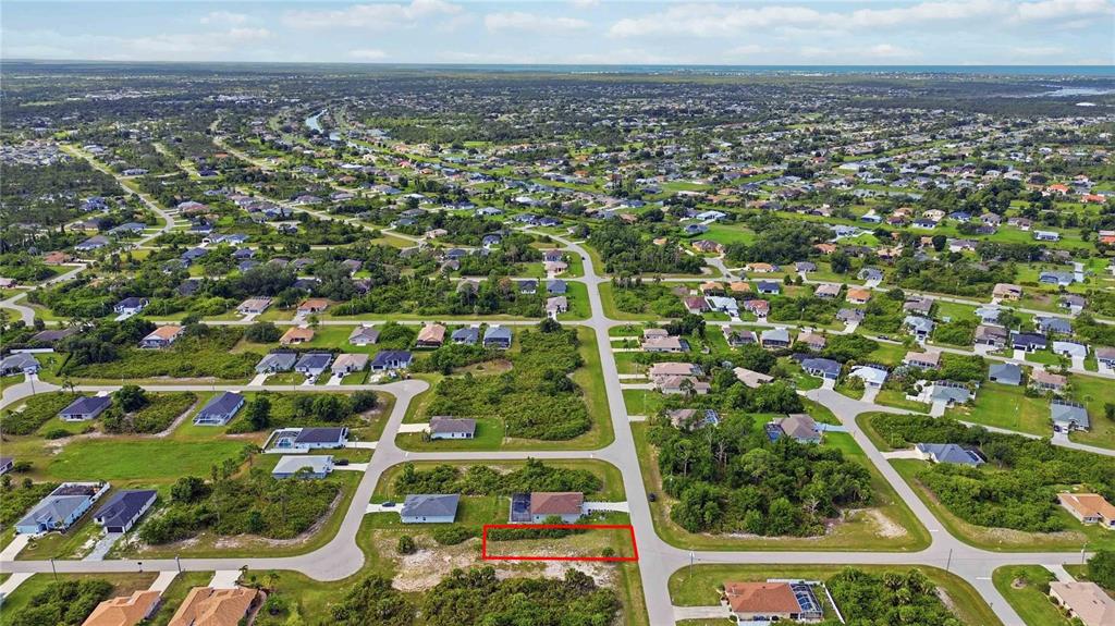 An aerial view shows a vacant residential lot outlined in red within a suburban neighborhood — 116 ANTIS DRIVE, ROTONDA WEST, FL