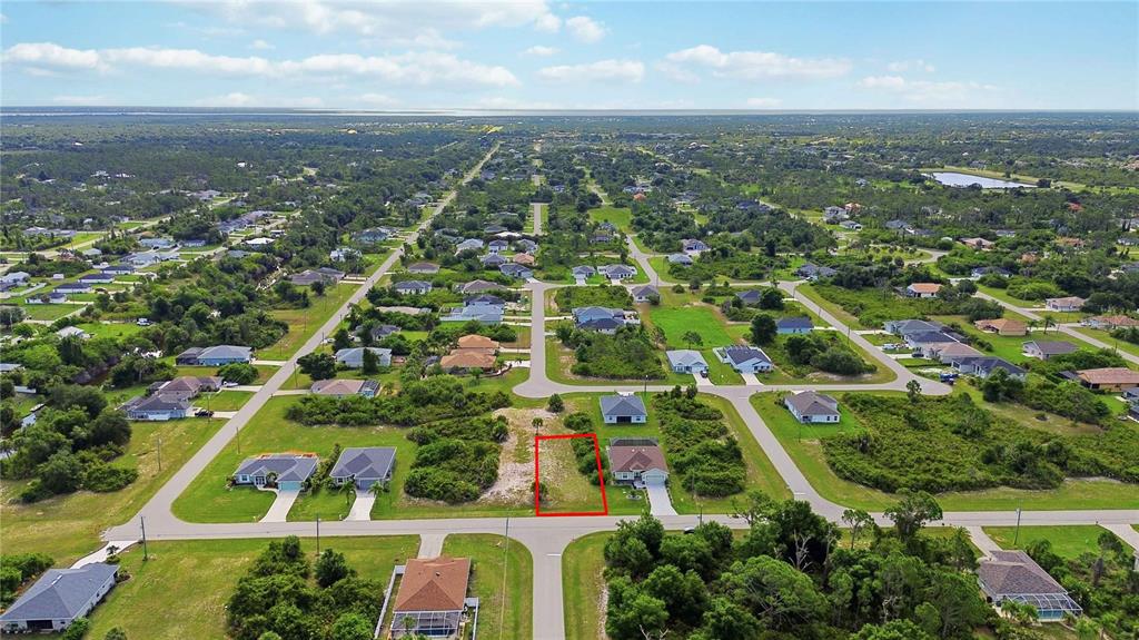 An aerial view shows a vacant residential lot outlined in red within a suburban neighborhood — 116 ANTIS DRIVE, ROTONDA WEST, FL