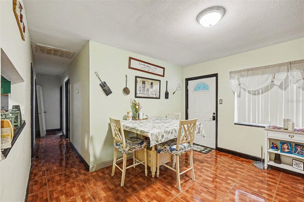 A dining area features tile flooring, a table with four chairs, and a white front door — 3040 STRAWBERRY LANE, LAKELAND, FL