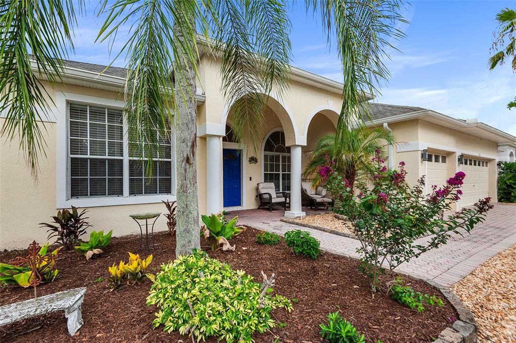 A single-story house with a blue front door, arched entryway, and landscaped front yard — 301 BIRKDALE STREET, DAVENPORT, FL