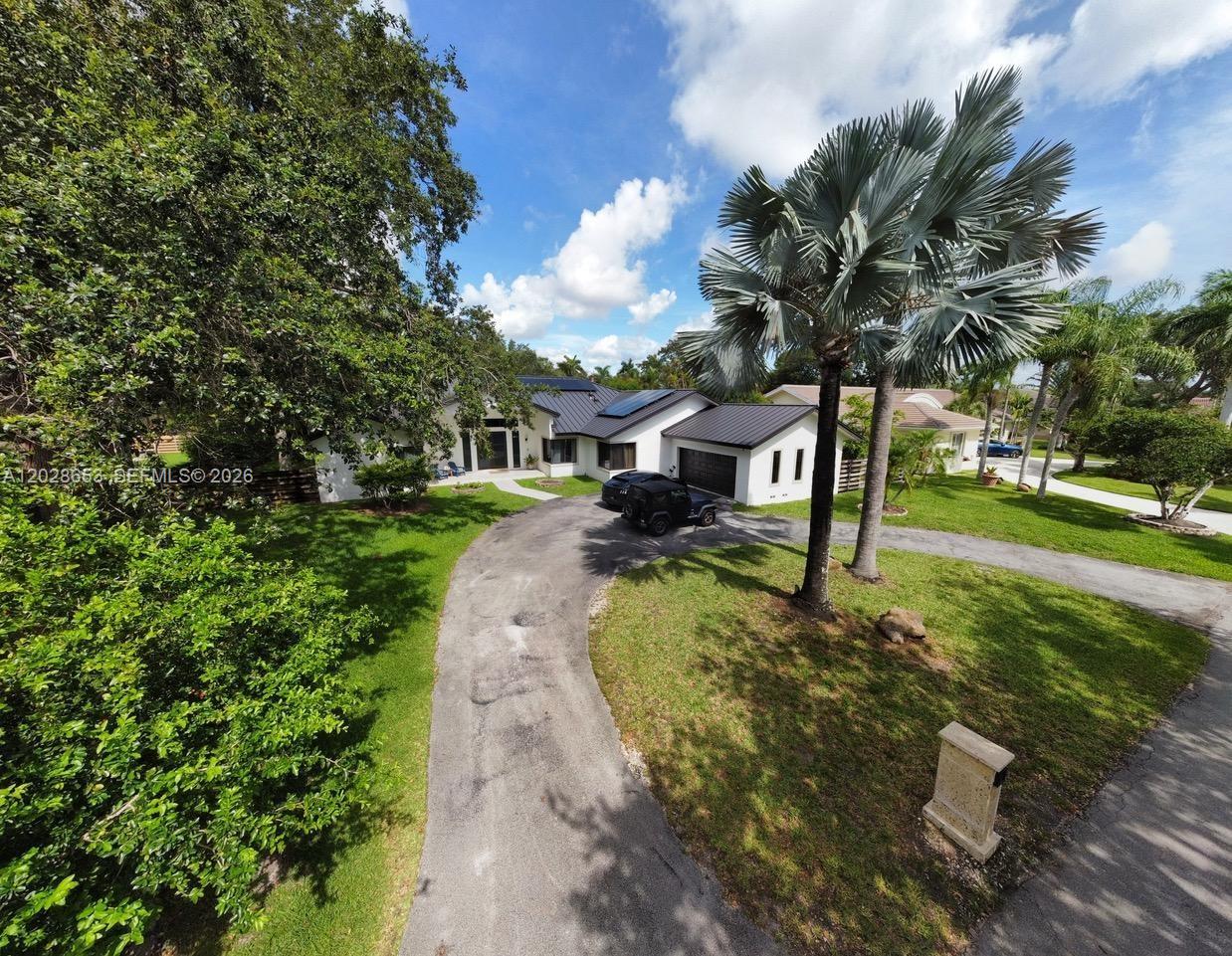 An aerial view shows a white house with a dark metal roof and circular driveway — 13324 SW 106th Ave, Miami FL 33176, MIAMI, FL