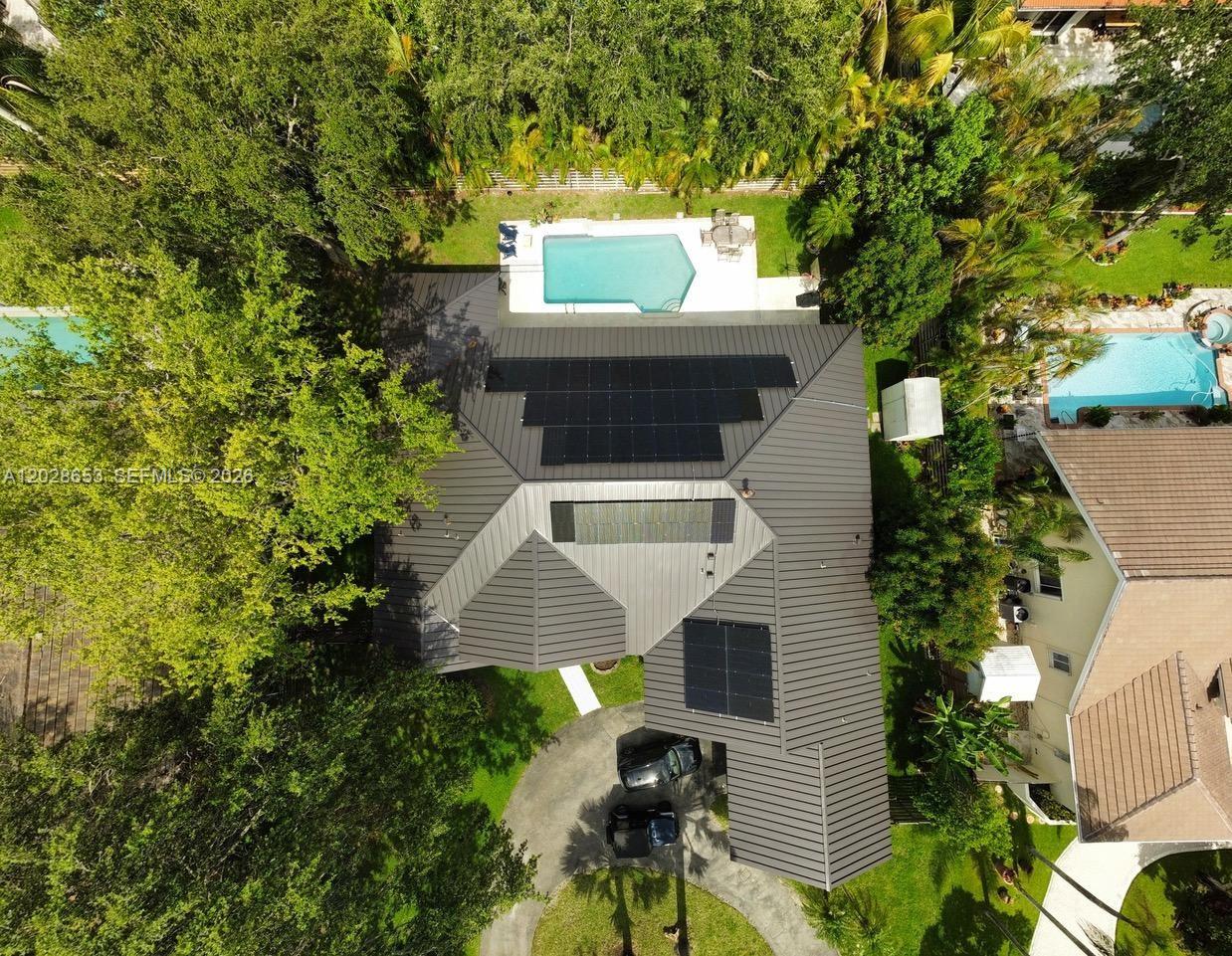 An aerial view shows a house with a metal roof, solar panels, and a swimming pool — 13324 SW 106th Ave, Miami FL 33176, MIAMI, FL