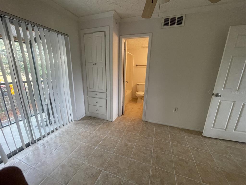 A room with tiled flooring, a built-in cabinet, a doorway to a bathroom, and blinds — 139 OYSTER BAY CIRCLE UNIT 340, ALTAMONTE SPRINGS, FL