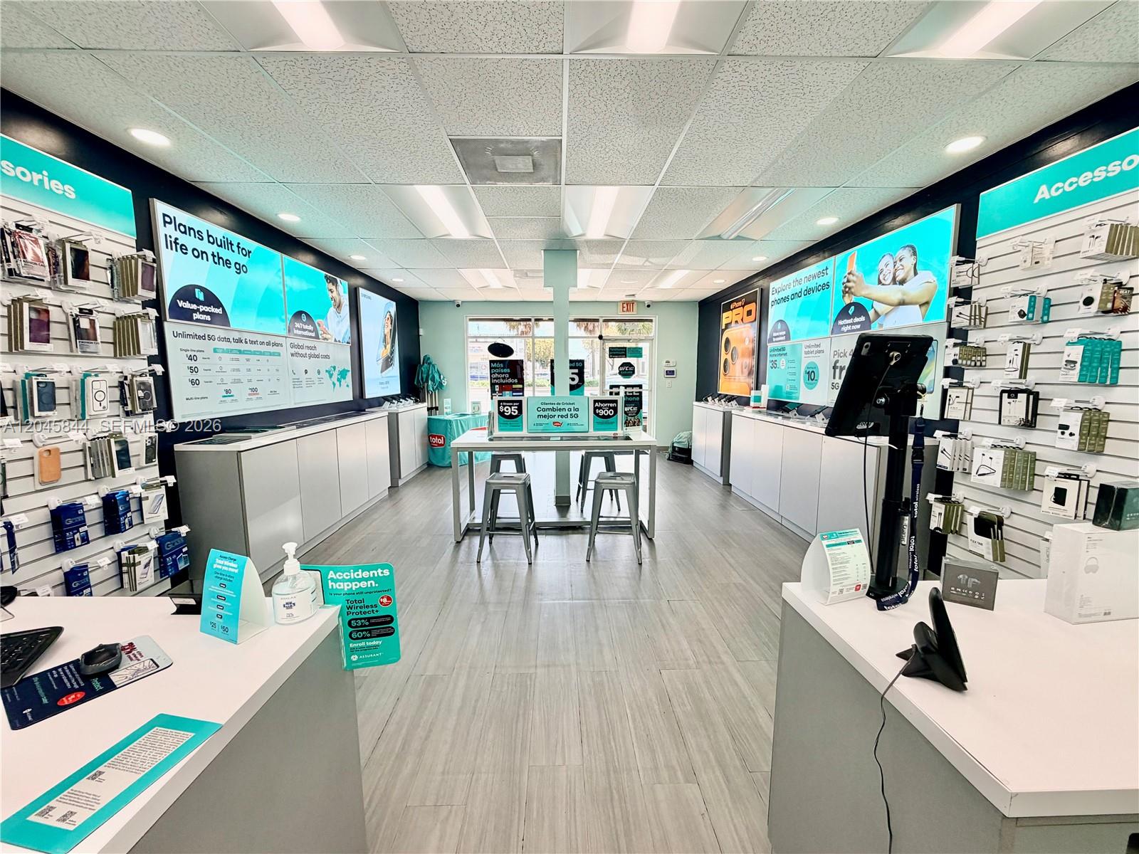 A brightly lit retail store interior features product display walls, a central table, and white counters — confidential, Hialeah Gardens 00000, HIALEAH GARDENS, FL