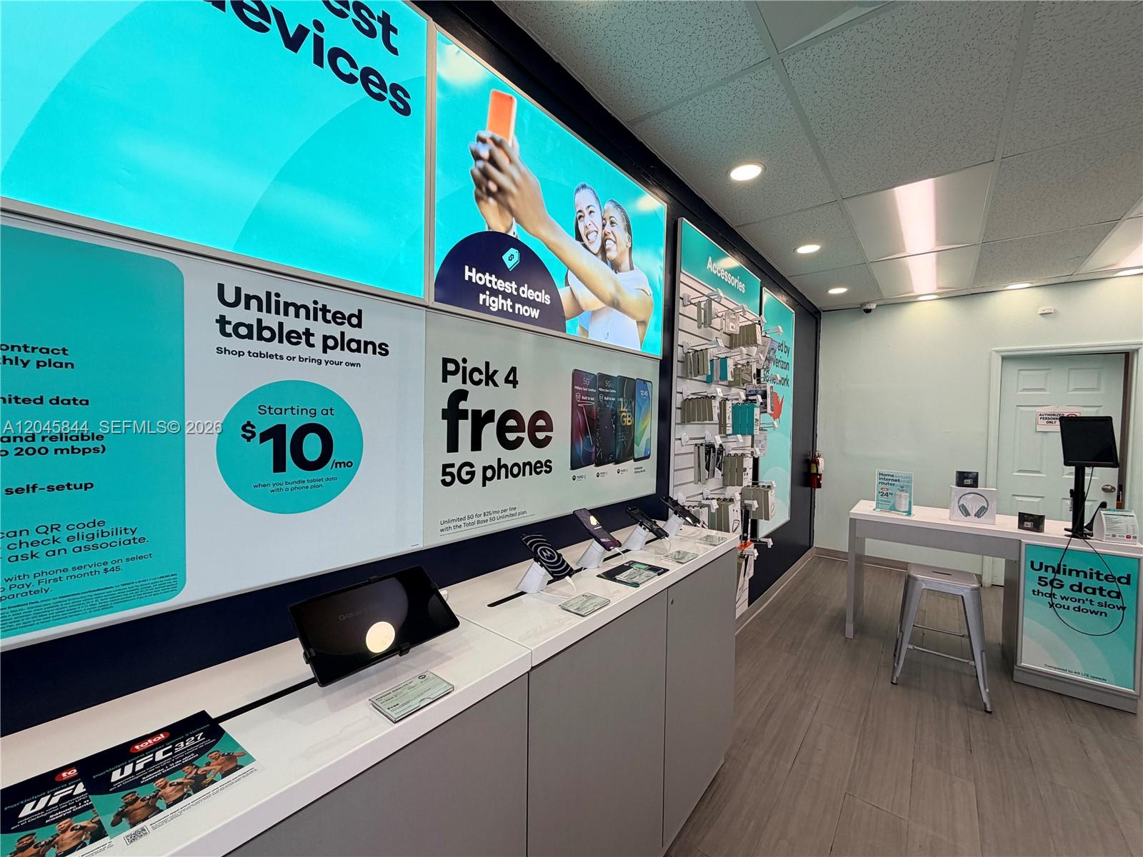 A retail store interior features product display counters, promotional signage on walls, and wood-look flooring — confidential, Hialeah Gardens 00000, HIALEAH GARDENS, FL