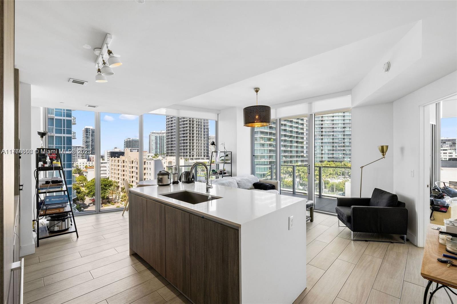 A modern kitchen island with a sink sits in an open-concept living space with floor-to-ceiling windows — 2900 NE 7th Ave # 901, Miami FL 33137, MIAMI, FL