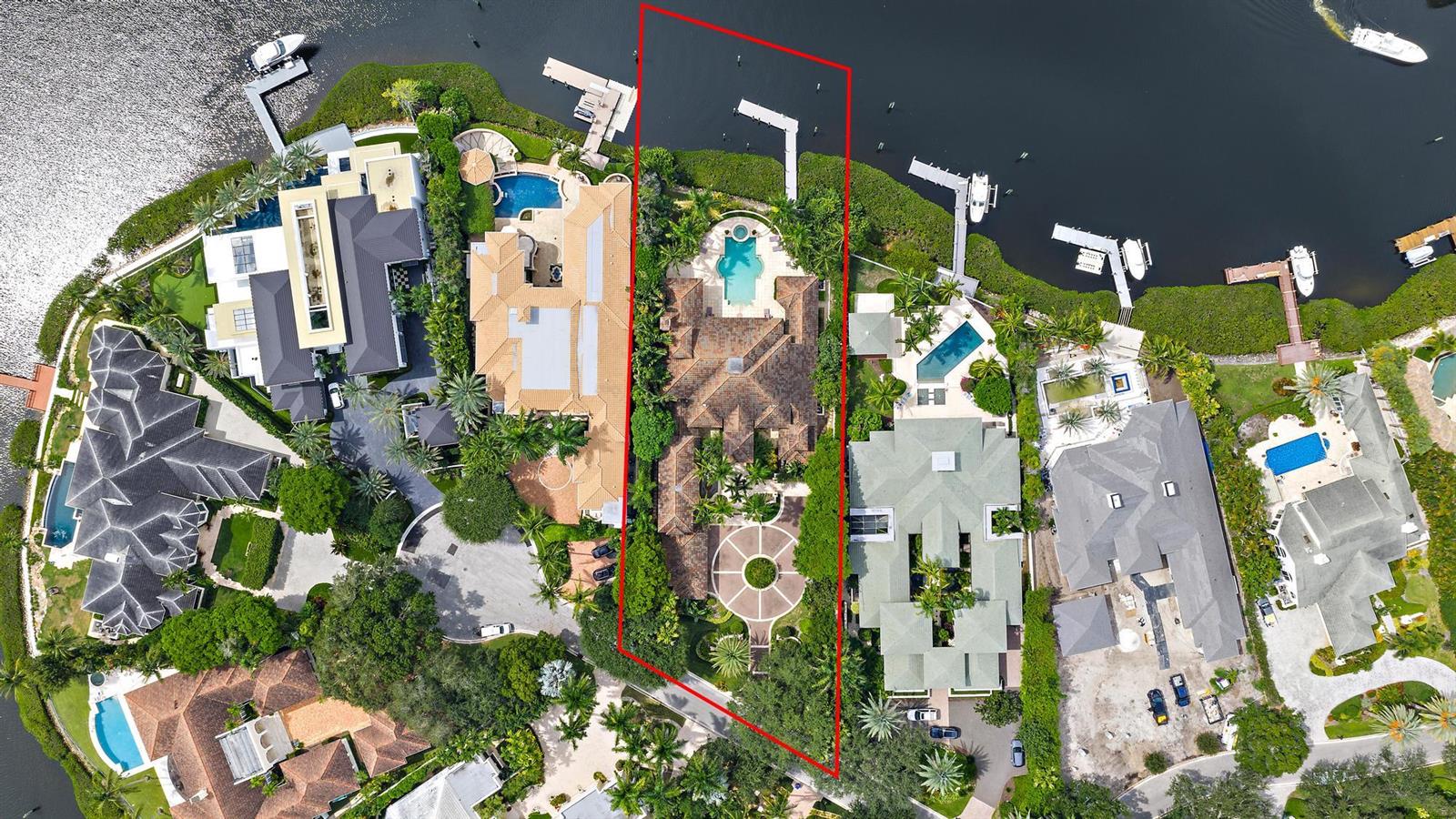 An aerial view shows a waterfront luxury home with a pool and circular driveway — 193 Spyglass Court, Jupiter FL 33477, JUPITER, FL
