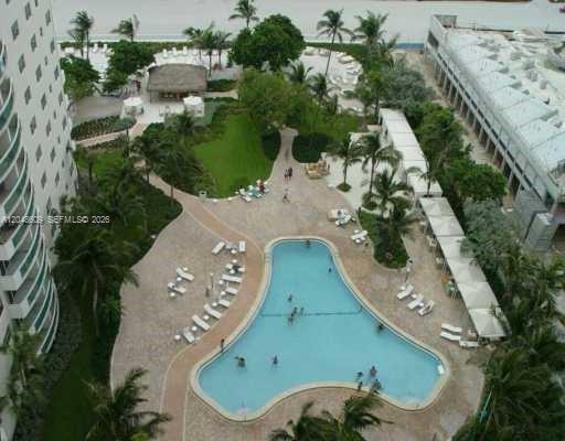 An aerial view of a resort-style swimming pool surrounded by lounge chairs and palm trees — 3001 S Ocean Dr # 721, Hollywood FL 33019, HOLLYWOOD, FL