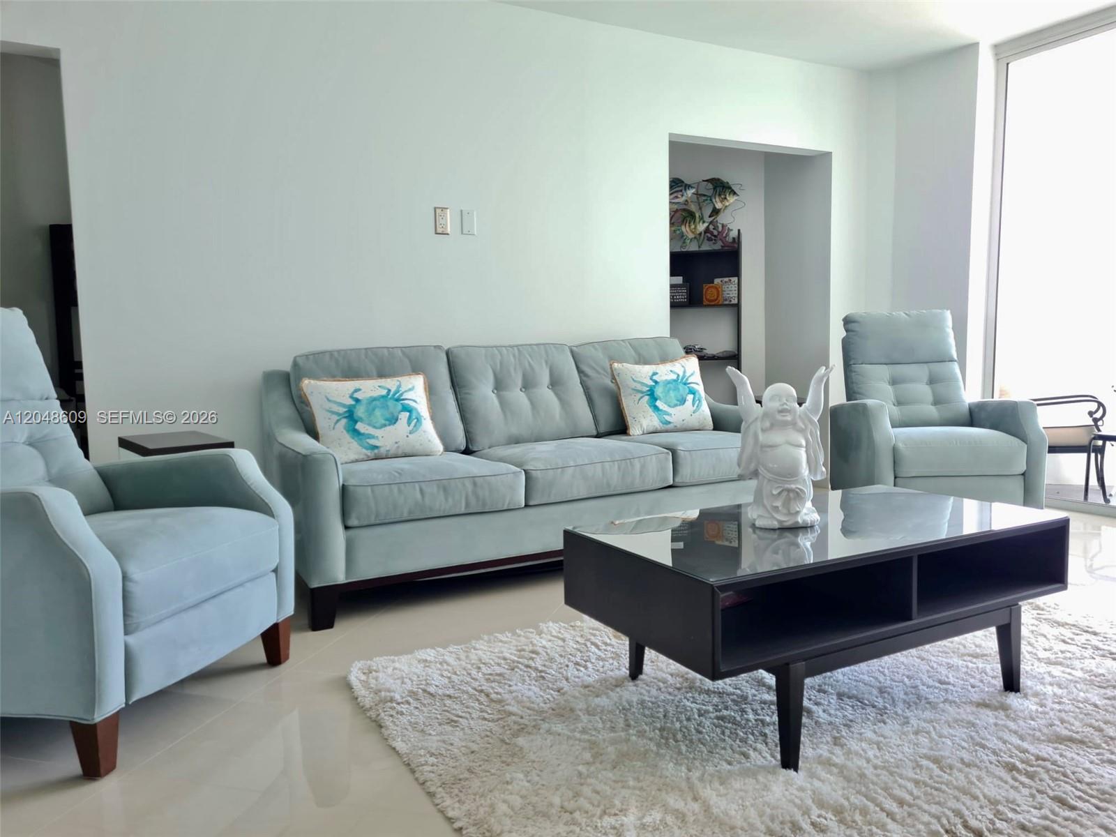 A living room features a light blue sofa, two matching armchairs, and a black coffee table — 3001 S Ocean Dr # 721, Hollywood FL 33019, HOLLYWOOD, FL