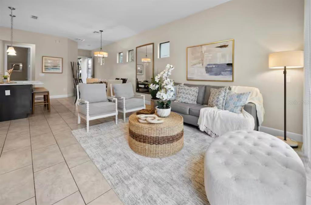 A living room features a gray sofa, two armchairs, a round coffee table, and tile flooring — 192 VILLA DOMANI CIRCLE, DAVENPORT, FL