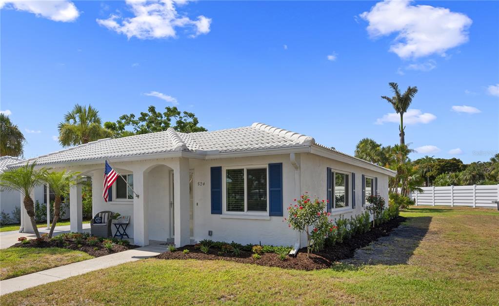 A white, single-story house with a tiled roof, blue shutters, and a front porch — 524 SPANISH DRIVE S UNIT 125, LONGBOAT KEY, FL