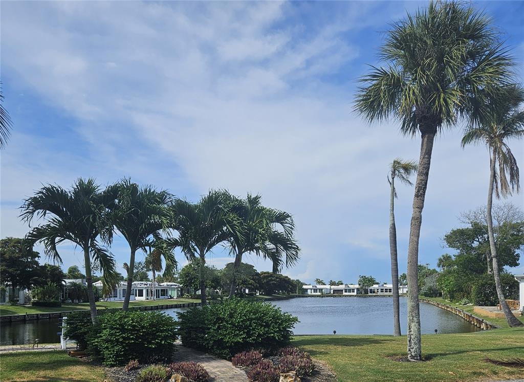 A view of a canal with palm trees and houses in the background — 524 SPANISH DRIVE S UNIT 125, LONGBOAT KEY, FL