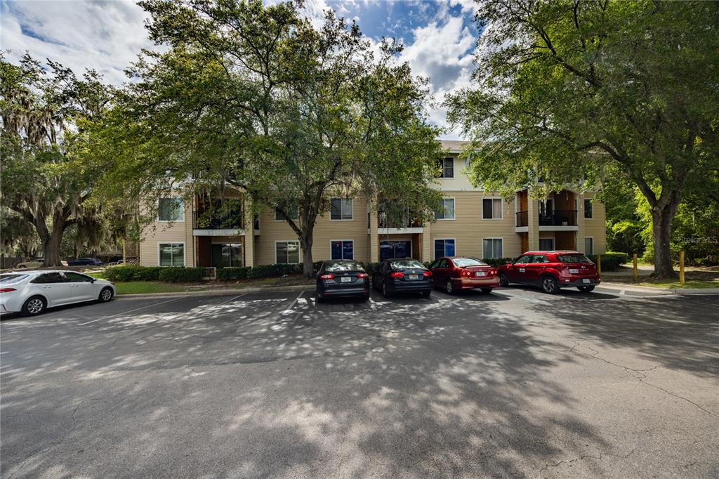 An exterior view of an apartment entrance with a black door and adjacent outdoor stairs — 3921 SW 34TH STREET UNIT 1C, GAINESVILLE, FL