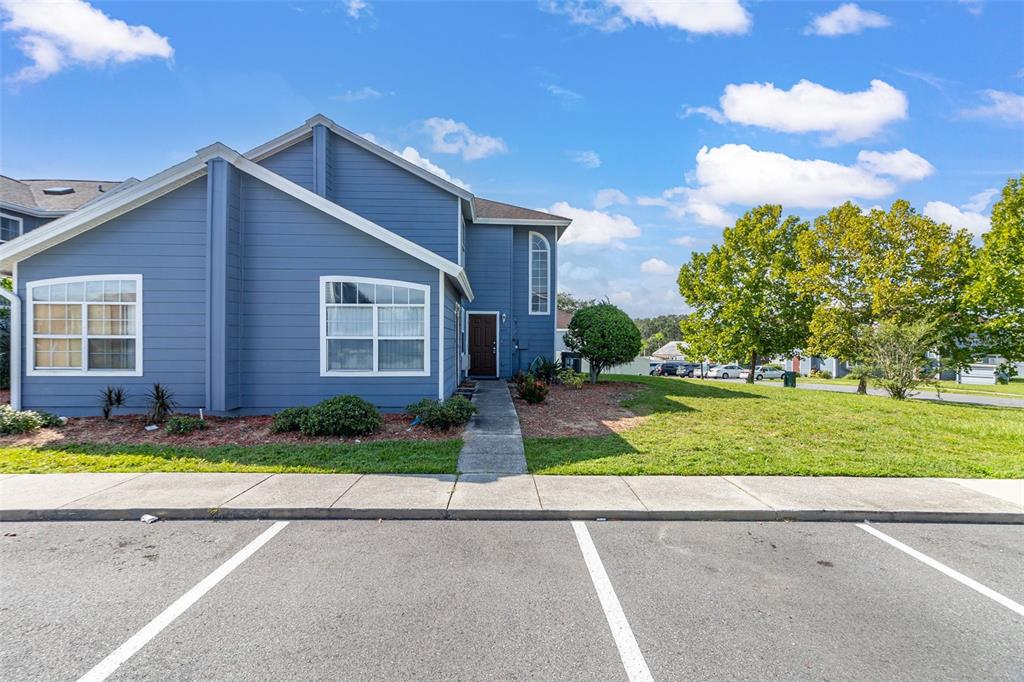 A blue two-story building with white trim and a concrete walkway sits near a parking lot — 403 ORCHID DRIVE, DAVENPORT, FL