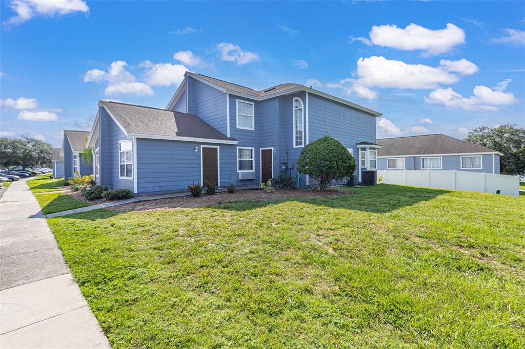 A blue two-story multi-family residential building with a lawn and a sidewalk — 403 ORCHID DRIVE, DAVENPORT, FL