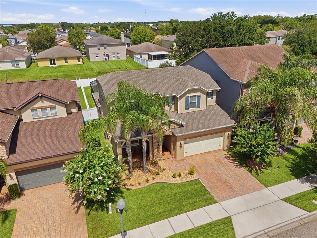 An aerial view of a two-story suburban house with a brick driveway and palm trees — 1114 FOUNTAIN COIN LOOP, ORLANDO, FL