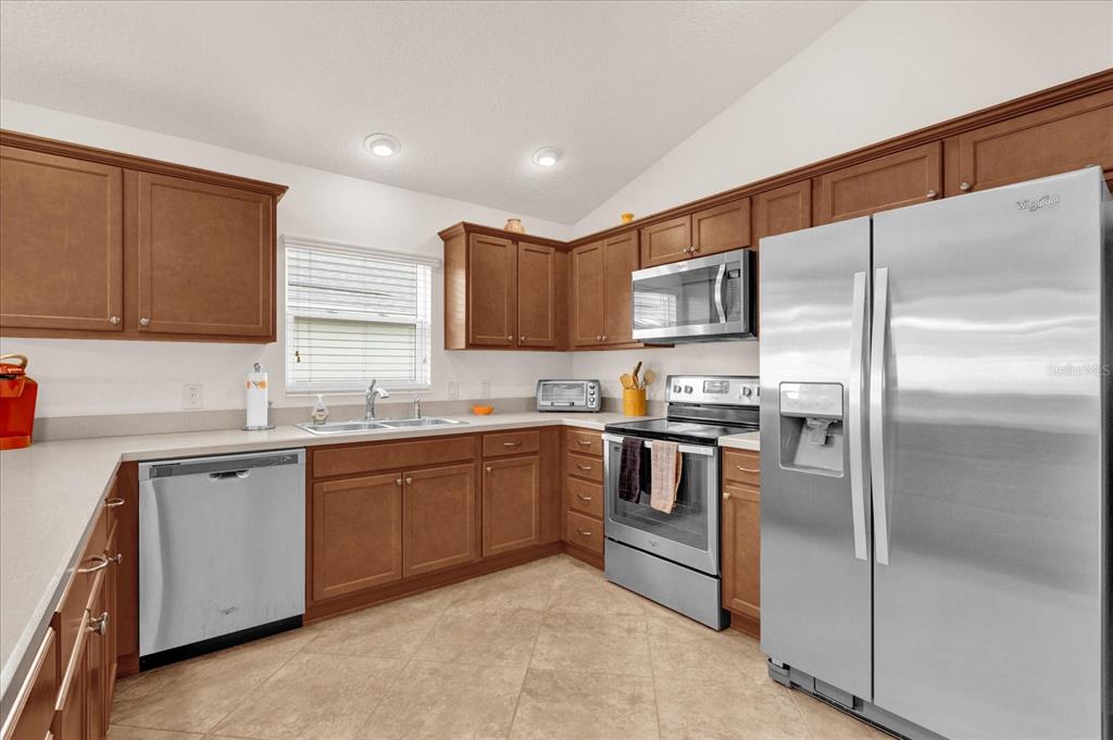 A kitchen with wood cabinets, stainless steel appliances, and light-colored countertops — 2850 CHARLEVOIX STREET, THE VILLAGES, FL