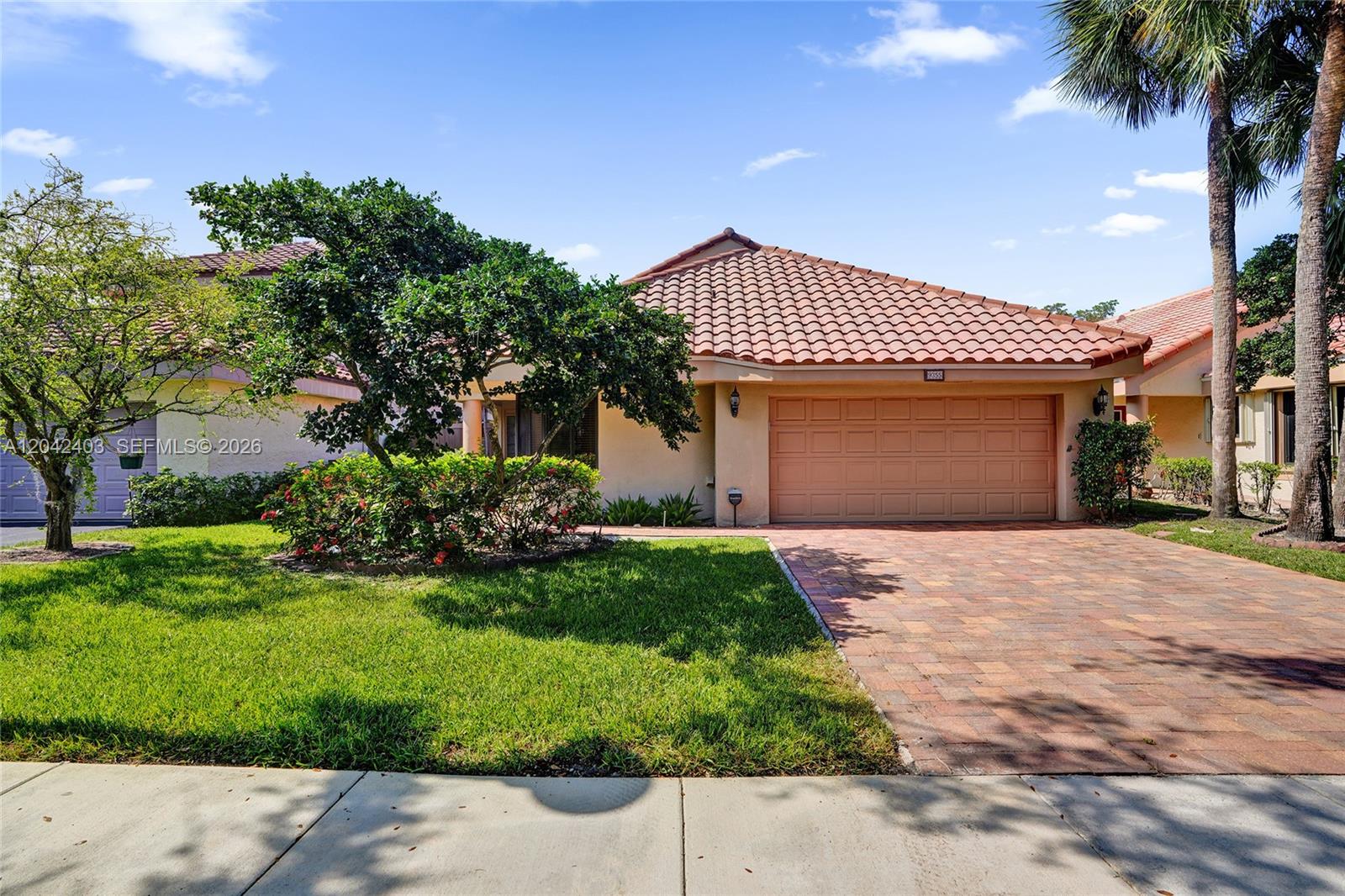 A single-story house with a tiled roof, a brick driveway, and a two-car garage — 9355 NW 18th Pl, Plantation FL 33322, PLANTATION, FL