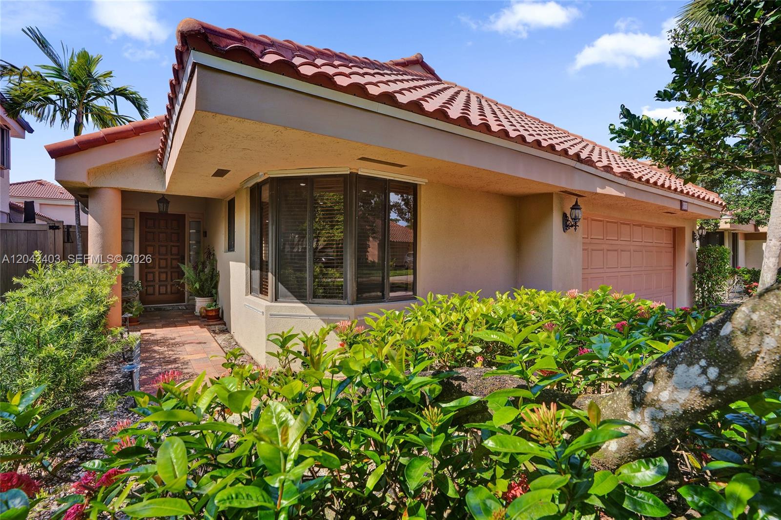 The exterior of a single-story house features a tiled roof, a bay window, and a garage — 9355 NW 18th Pl, Plantation FL 33322, PLANTATION, FL