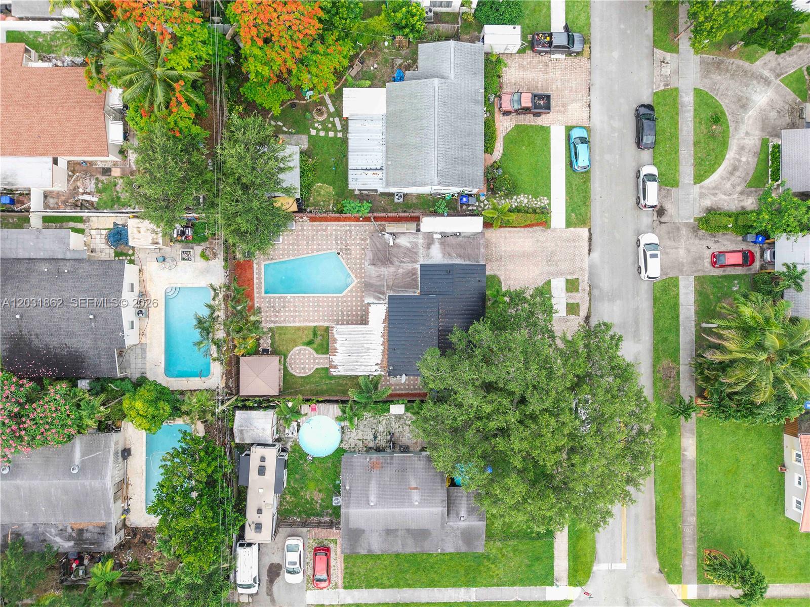 An aerial view shows several residential properties with swimming pools, driveways, and parked vehicles — 6810 Douglas St, Hollywood FL 33024, HOLLYWOOD, FL