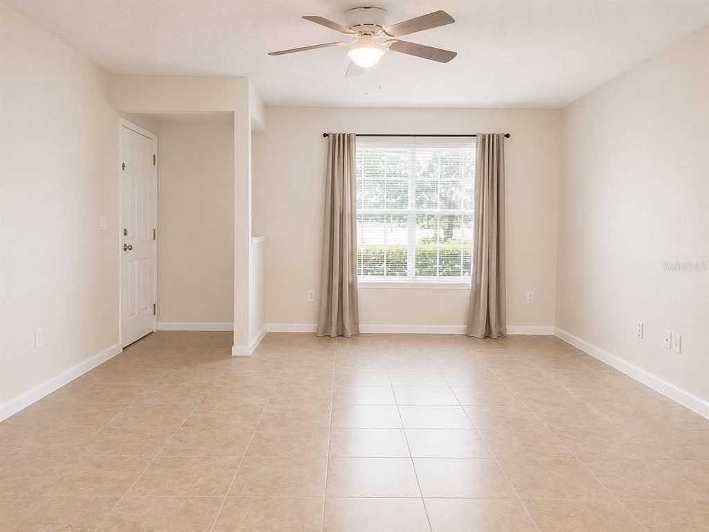 A room with light-colored tile flooring, a ceiling fan, and a window with curtains — 172 RESERVE CIRCLE UNIT 100, OVIEDO, FL