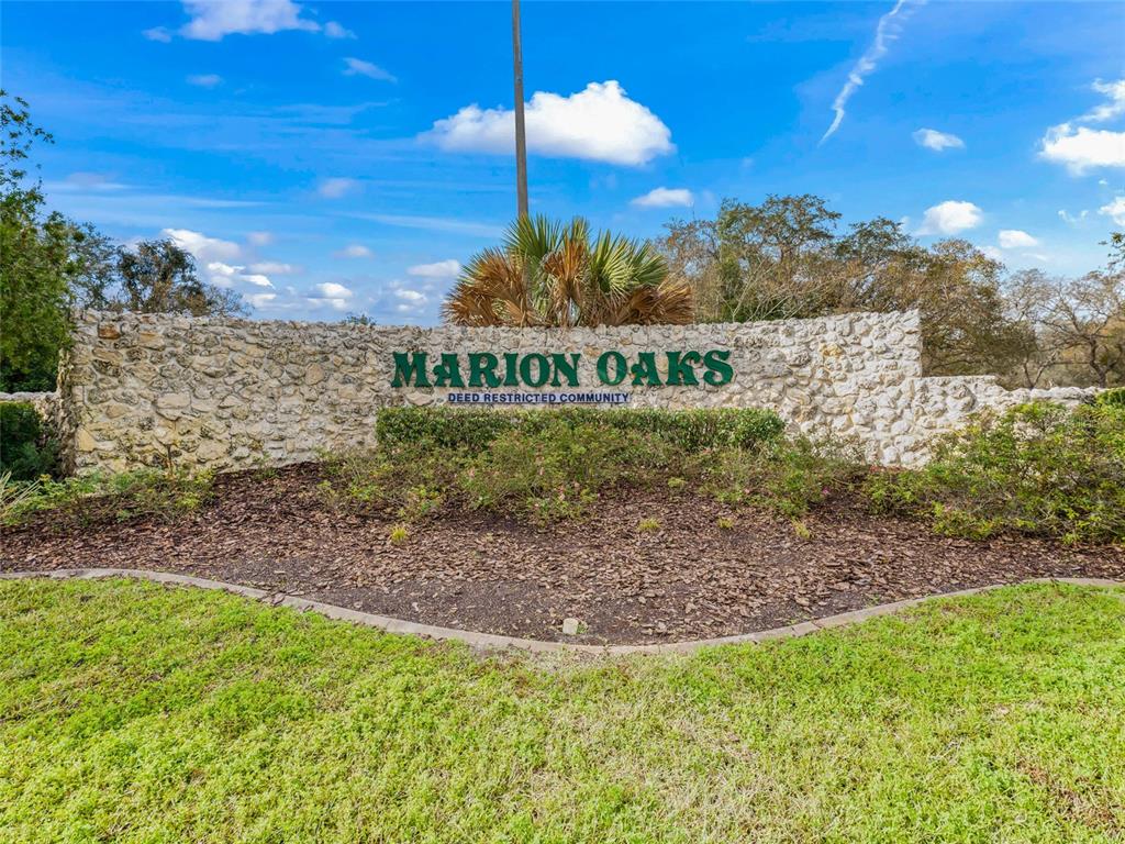 A stone wall with the text Marion Oaks stands in front of trees and grass — TBD SW 148 PL. RD, OCALA, FL