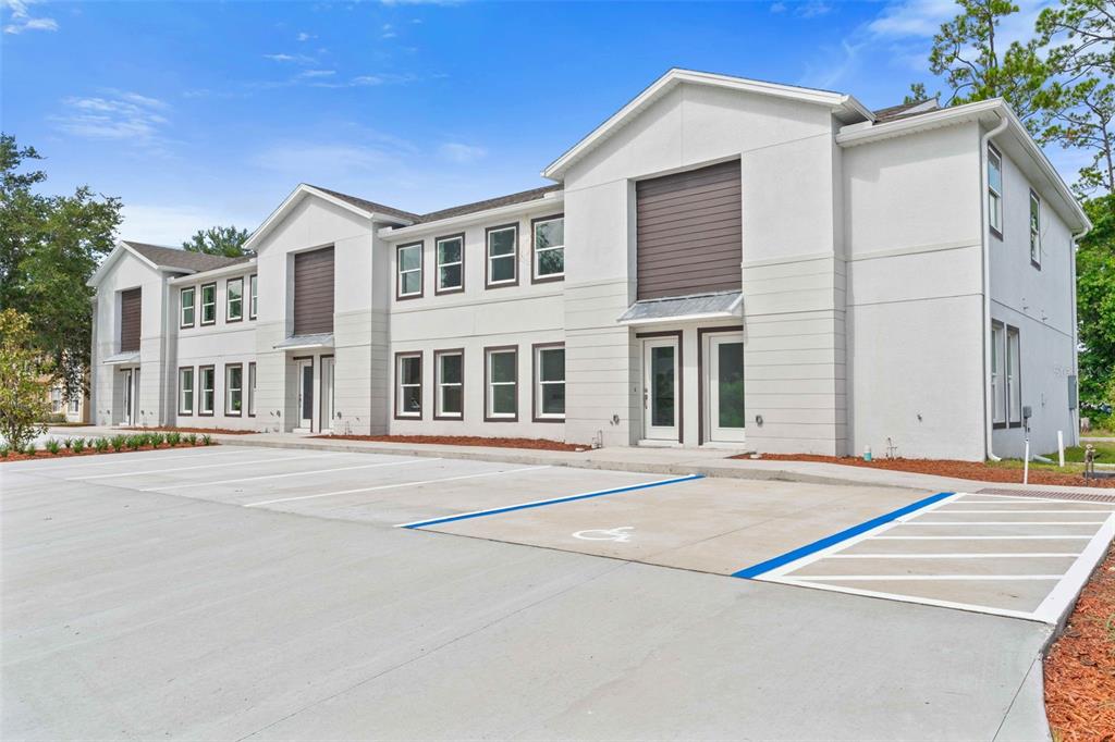 A two-story white commercial building features a concrete parking lot with a handicap space — 172 BOWIE LANE UNIT B, KISSIMMEE, FL
