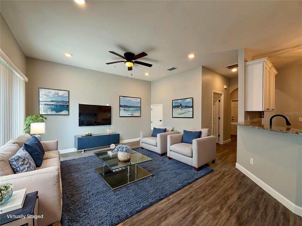 A light blue multi-unit residential building with white garage doors and a landscaped front yard — 2604 TANOAK TERRACE, WINTER HAVEN, FL