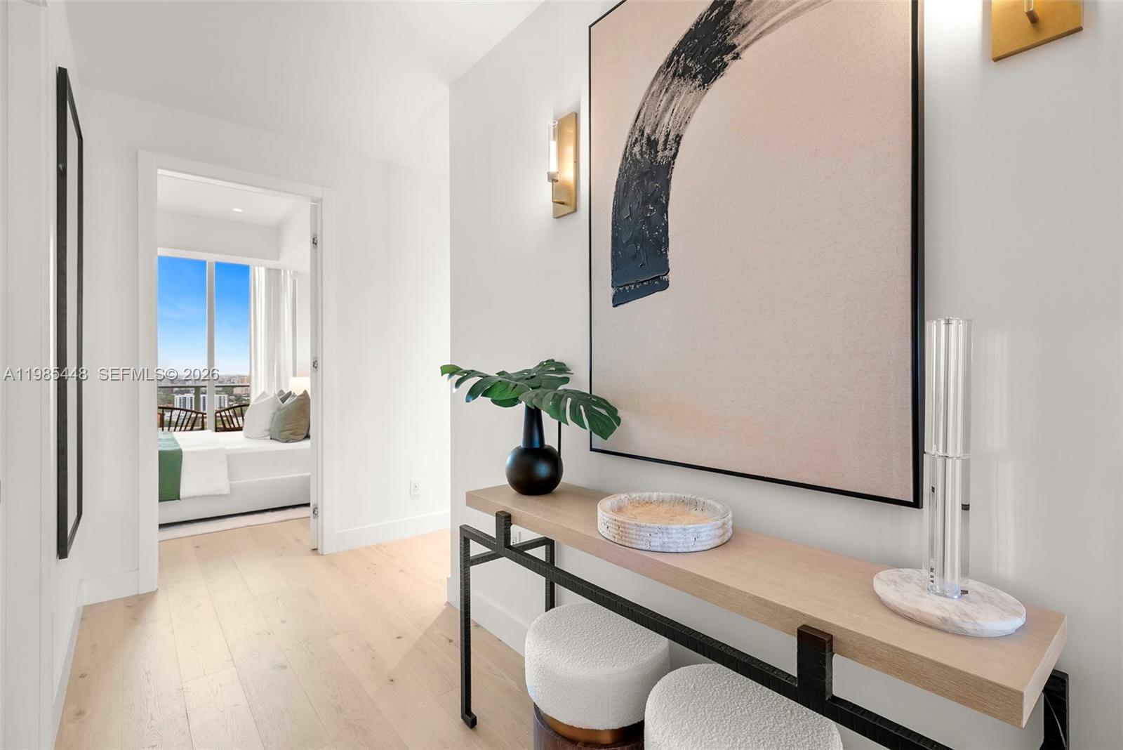 A hallway features a console table, abstract wall art, and a view into a bedroom — 2627 S Bayshore Dr # 2904, Miami FL 33133, MIAMI, FL