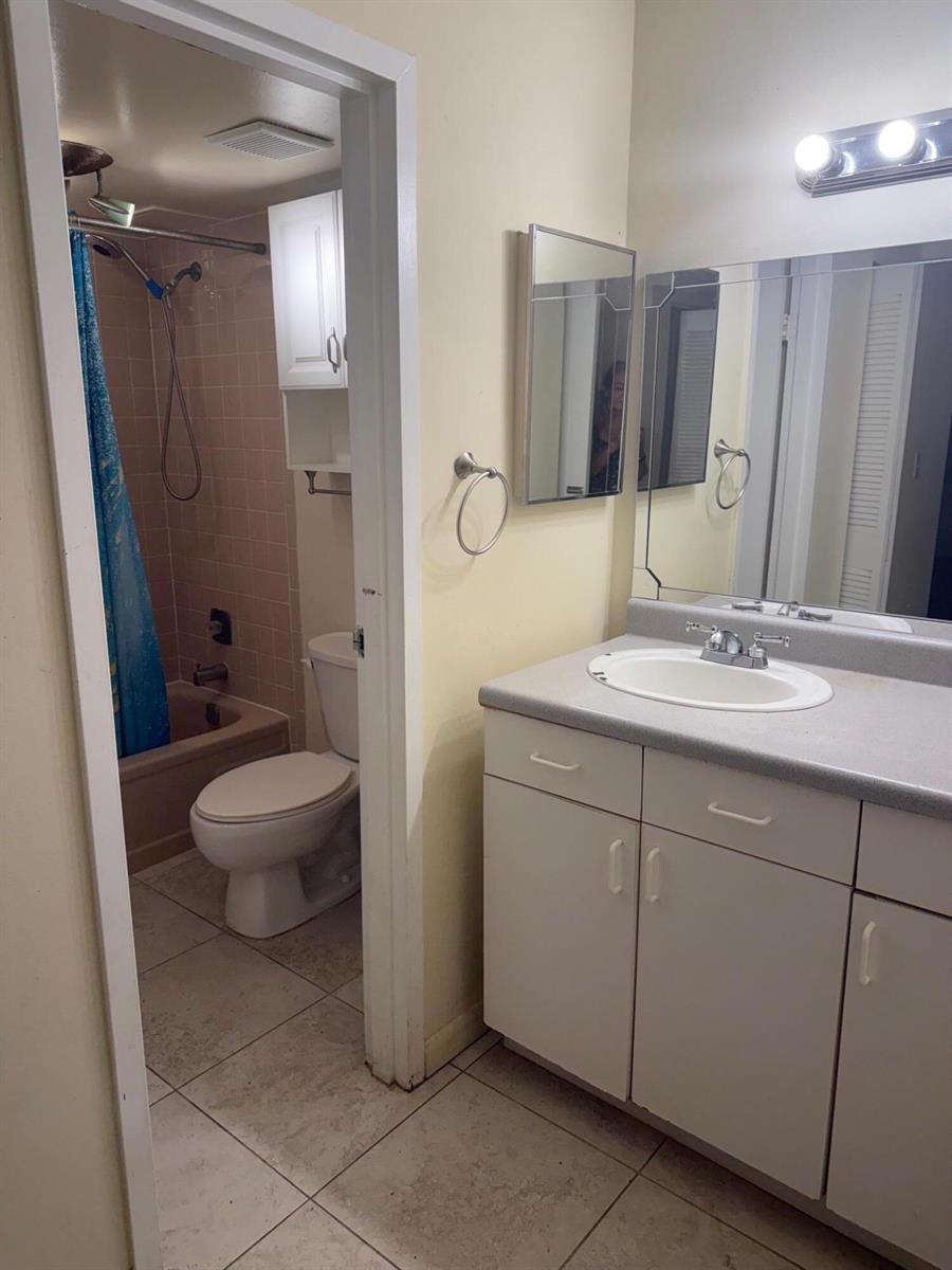 A bathroom features a vanity with a gray countertop and a separate room with a toilet — 4394 NW 9th Avenue # 1a, Pompano Beach FL 33064, POMPANO BEACH, FL