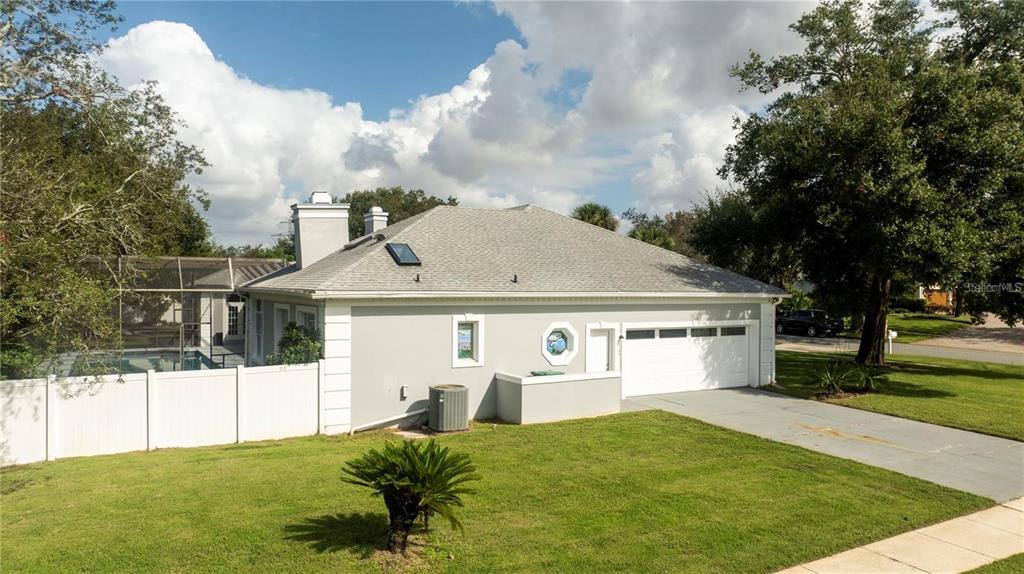 A side view of a gray house with a white garage door and fenced pool — 5646 MASTERS BOULEVARD, ORLANDO, FL