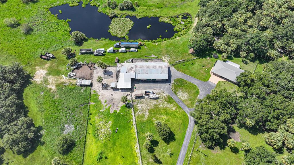 An aerial view shows a rural property with a house, large barn, and a pond — 43451 & 43631 FARABEE ROAD, PUNTA GORDA, FL