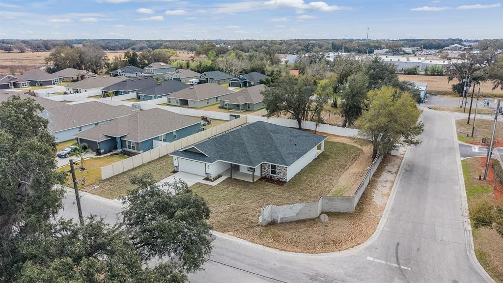 An aerial view shows a single-story house with a gray roof and a corner lot — 38086 COUNTRYSIDE PLACE, DADE CITY, FL